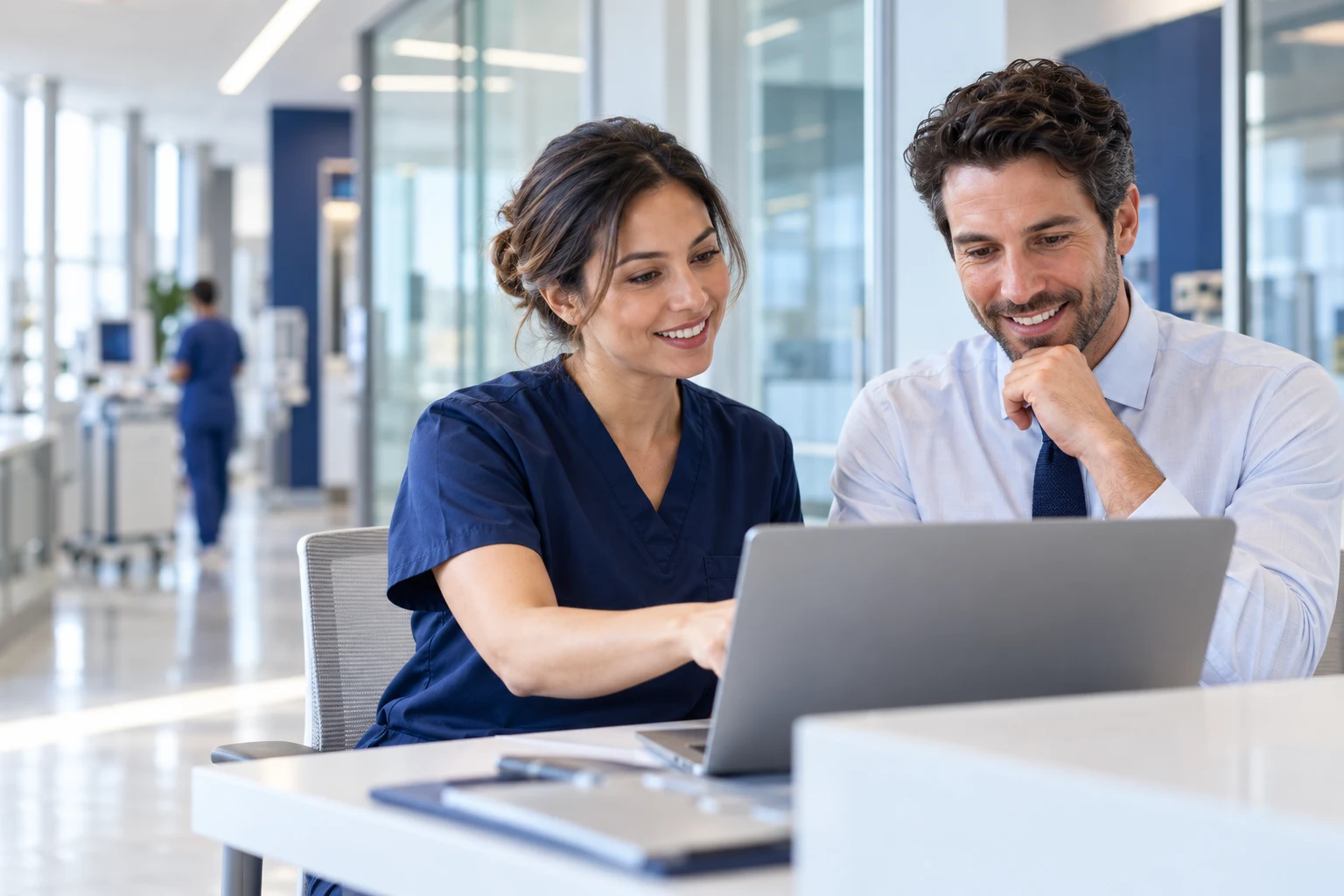 Healthcare clinician and technology analyst collaborating at a hospital workstation